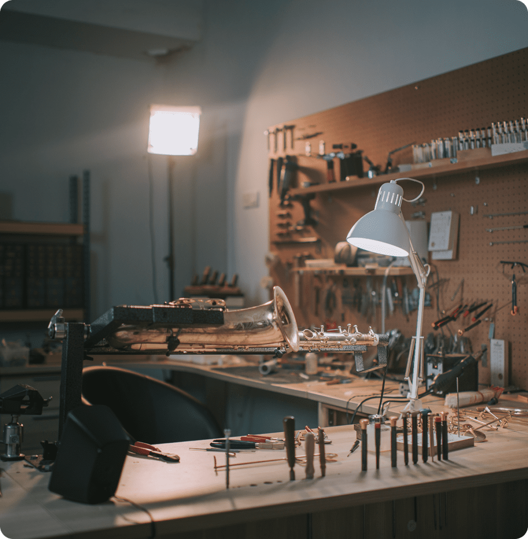 Instrument repair workshop with tools and saxophone.
