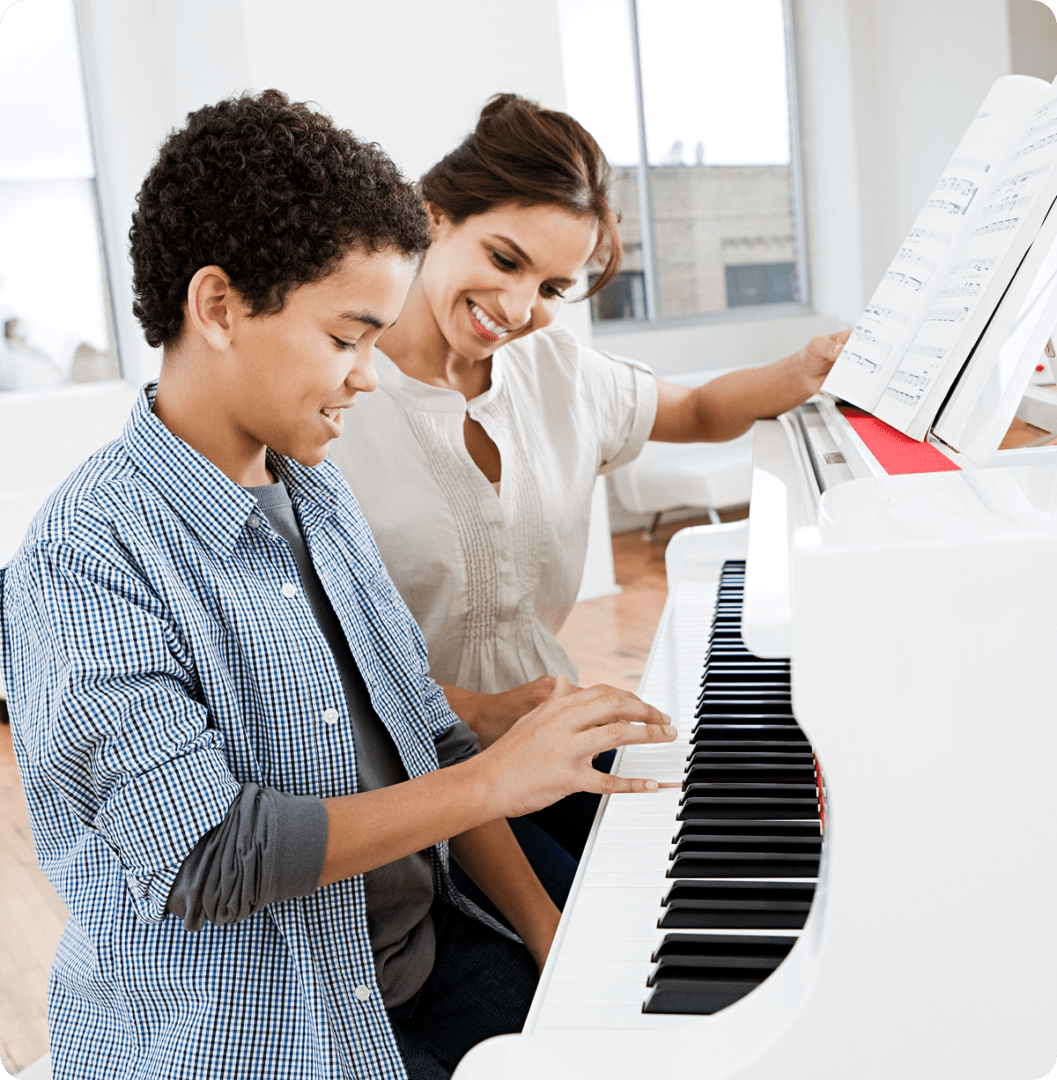 Woman guiding boy at piano keys